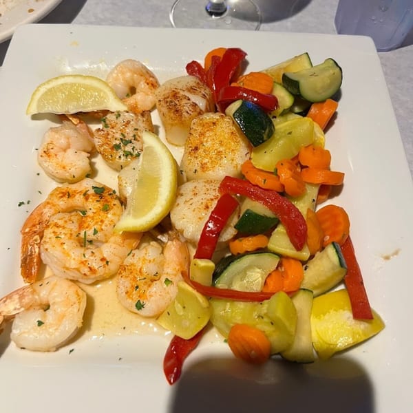 Bum Rogers Crab House & Tavern's shrimp and scallops with mixed vegetables and lemon wedges.